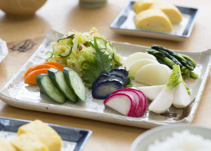 A white, ceramic serving tray of pickled vegetables.